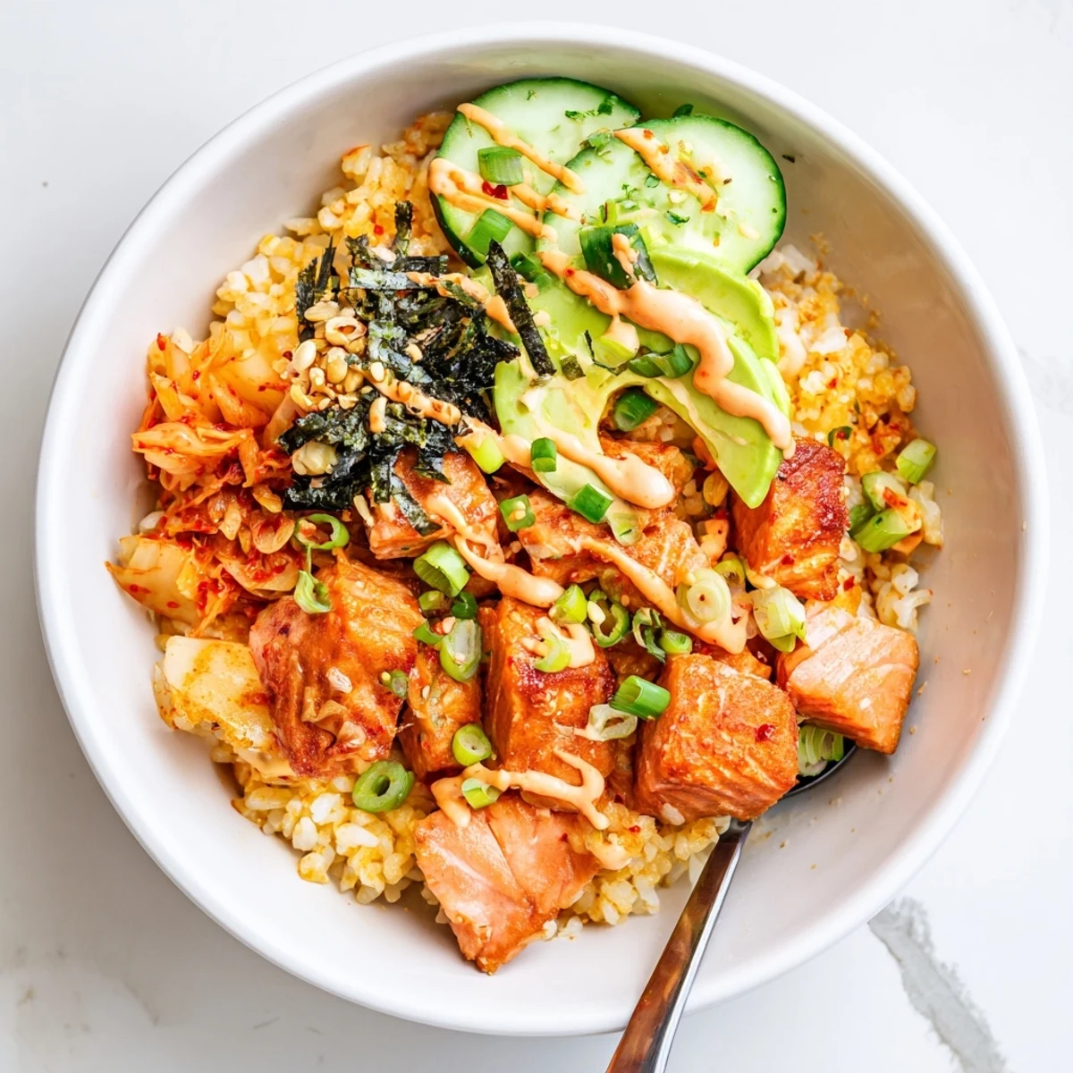 Enjoy this mouthwatering Crispy Salmon Rice Bowl with fresh cucumber slices.