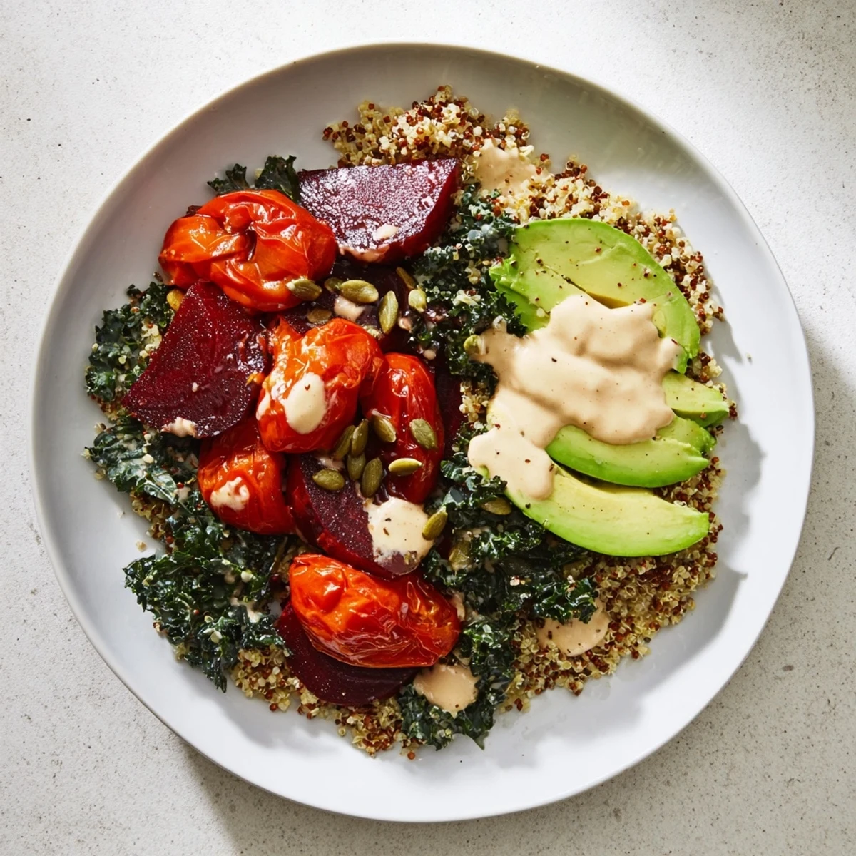 This healthy Quinoa, Kale & Roasted Beet Bowl features a beautiful kale base, drizzled with tahini dressing.
