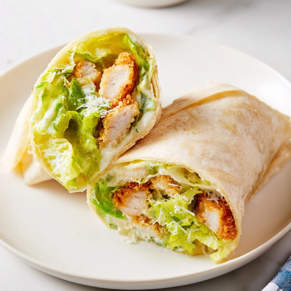 Served on a rustic wooden board, the Crispy Chicken Caesar Wrap is garnished with extra Parmesan and lemon wedges.