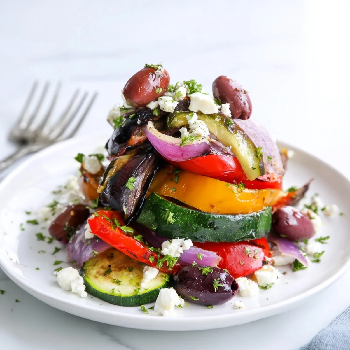 Roasted Greek Salad with caramelized vegetables, olives, feta, and fresh parsley on a platter.  
