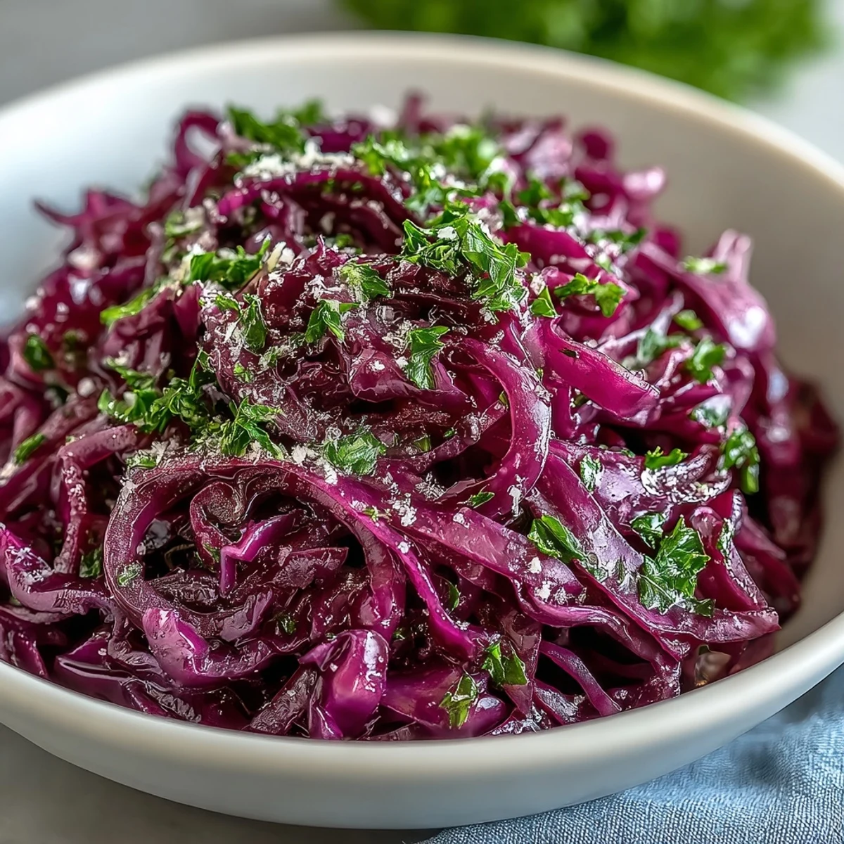 Bright purple cabbage, green apple matchsticks, and savory cheese create a vibrant Red Cabbage Coleslaw With Apple and Parmesan side salad.