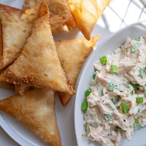 Golden, crispy air fryer lumpia chips alongside creamy chicken cream cheese dip, a delicious appetizer.