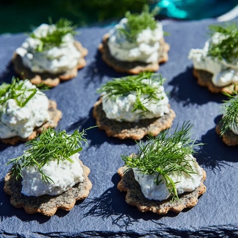 Crumbly goat cheese "whitecaps" topping wavy charcoal crackers, a refreshing take on The Stormy Sea appetizer.