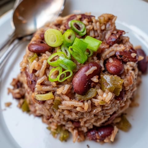 Creamy, budget-friendly Cajun Red Beans and Rice; top with green onions for serving.