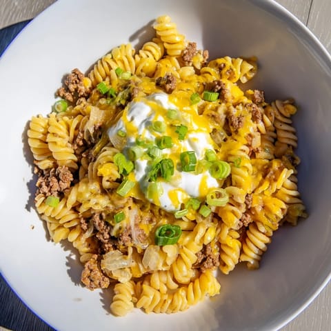 A bubbling Cheesy Taco Pasta Skillet—the savory aroma of ground beef and taco spices fills the air.