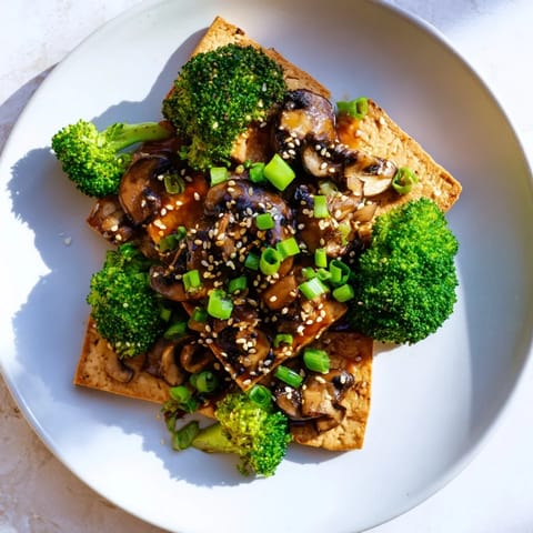 Delicious vegan meal: Sautéed Tofu Steak with tender broccoli and shiitake mushrooms, ready to eat.
