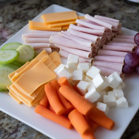 Make simple DIY Lunchables to pack for kids, featuring fresh veggies, meats, and crackers.