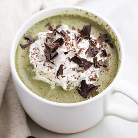 A close-up of a Matcha Hot Cocoa Protein Mug, a rich, green, and chocolate beverage.