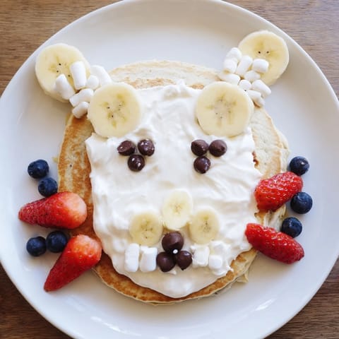 Delicious Polar Bear pancakes, stacked for family brunch, topped with blueberries and a chocolate spread.