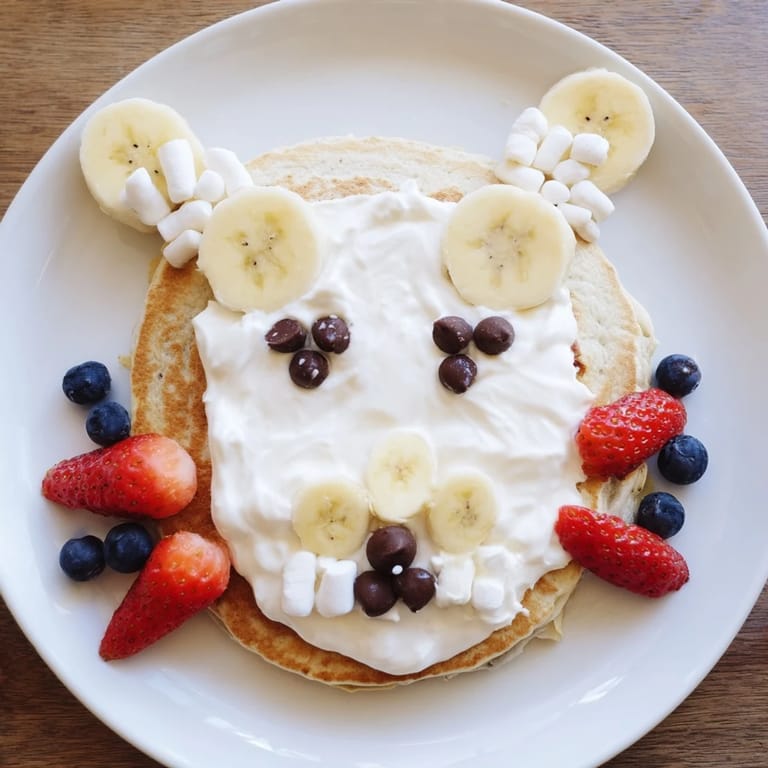 Delicious Polar Bear pancakes, stacked for family brunch, topped with blueberries and a chocolate spread.