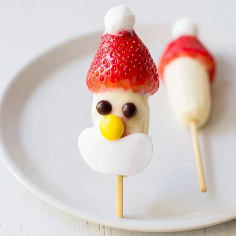 Delicious Banana Santa Snack Sticks: ripe banana slices with fresh strawberry hats are easy to make.
