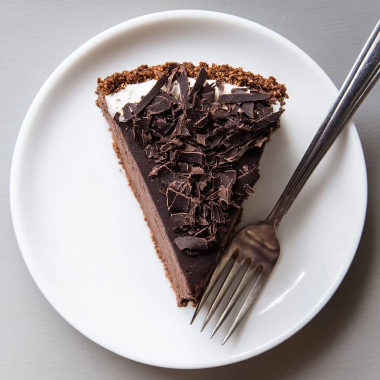 Decadent chocolate Lighter Chocolate Cottage Cheese Cheesecake served with a dollop of Greek yogurt and maple syrup drizzle.