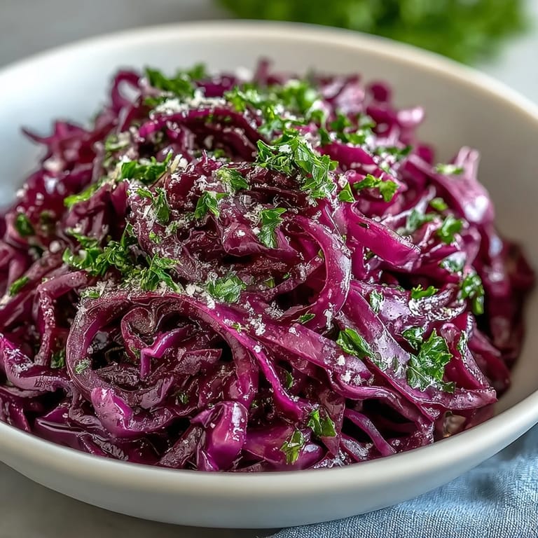 Bright purple cabbage, green apple matchsticks, and savory cheese create a vibrant Red Cabbage Coleslaw With Apple and Parmesan side salad.