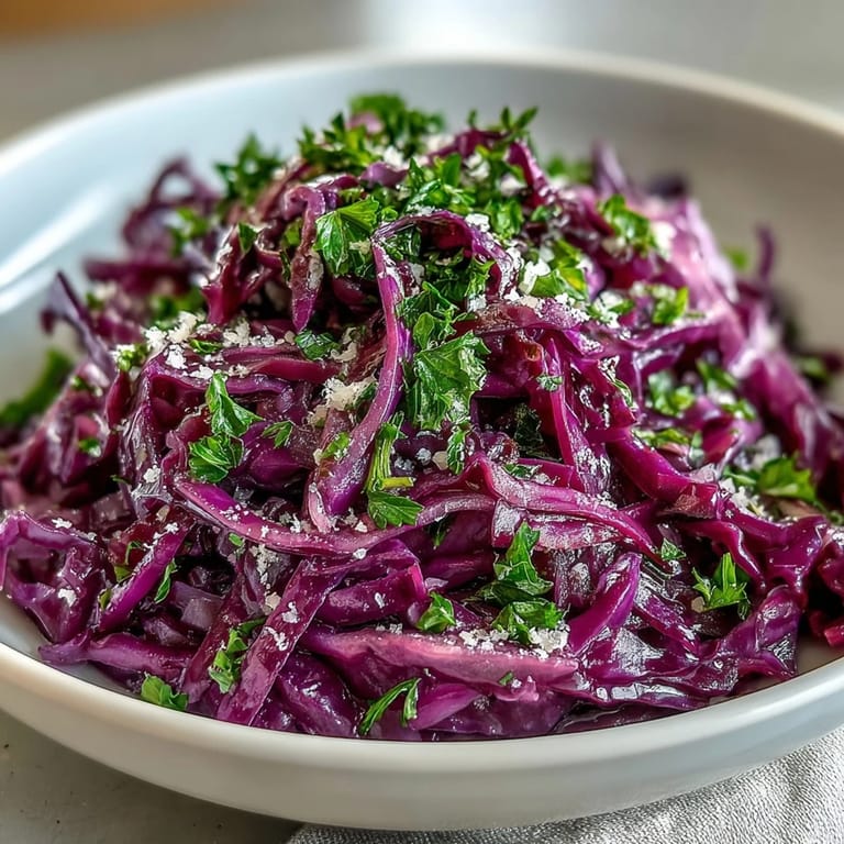 Served in a white ceramic bowl, this Red Cabbage Coleslaw With Apple and Parmesan offers a refreshing, gluten-free vegetarian meal option.